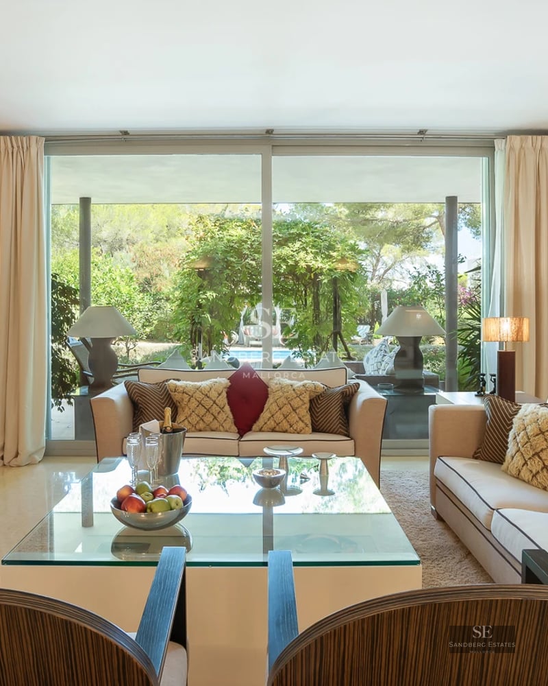 View of a luxurious villa with pool, garden, and modern design. Large windows and high-quality finishes. Warm lighting and relaxing atmosphere.