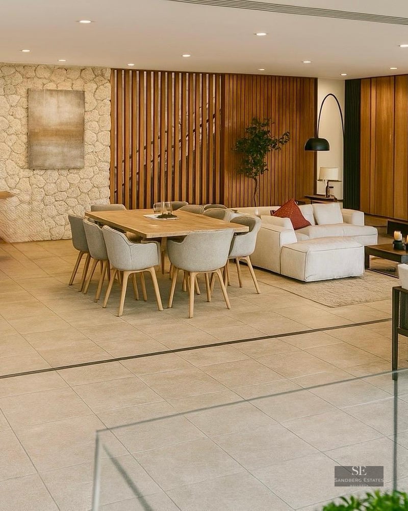 Modern open-plan room featuring sofas, dining tables, a stone feature wall, and fireplace under warm lighting.
