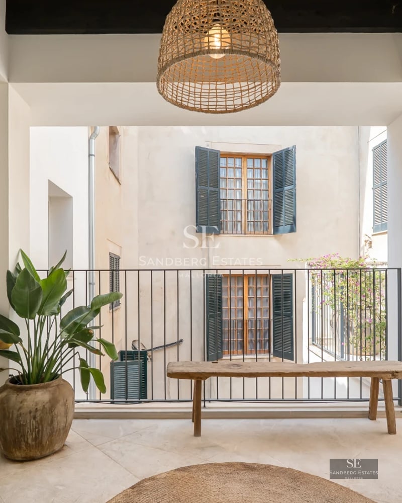 Spacious pool surrounded by a lush garden with modern furniture. House with large windows and elegant architectural design.