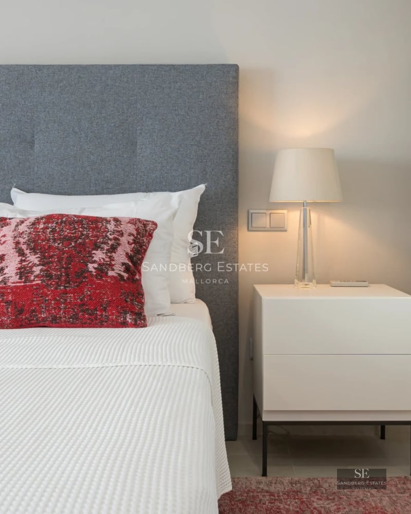 Spacious, bright living room with fireplace, panoramic windows, and minimalist decor. View of the Mediterranean Sea.