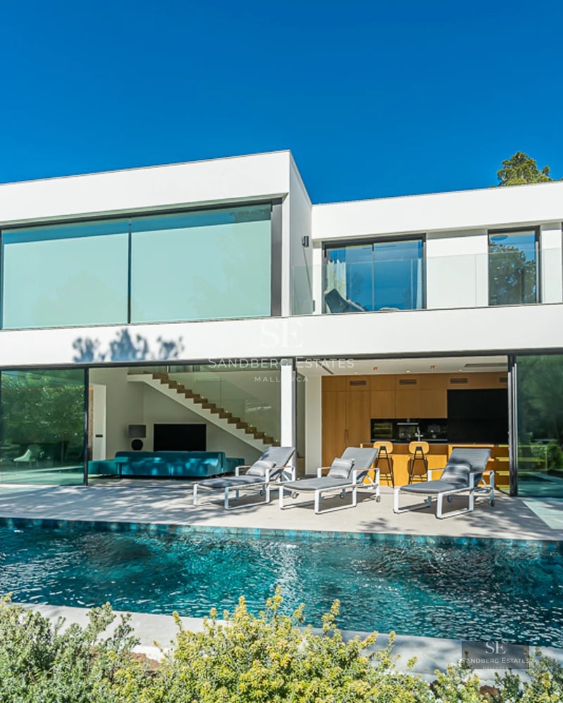 Vue extérieure d'une maison moderne avec piscine, jardin luxuriant et grandes fenêtres. Design élégant et finitions de haute qualité.