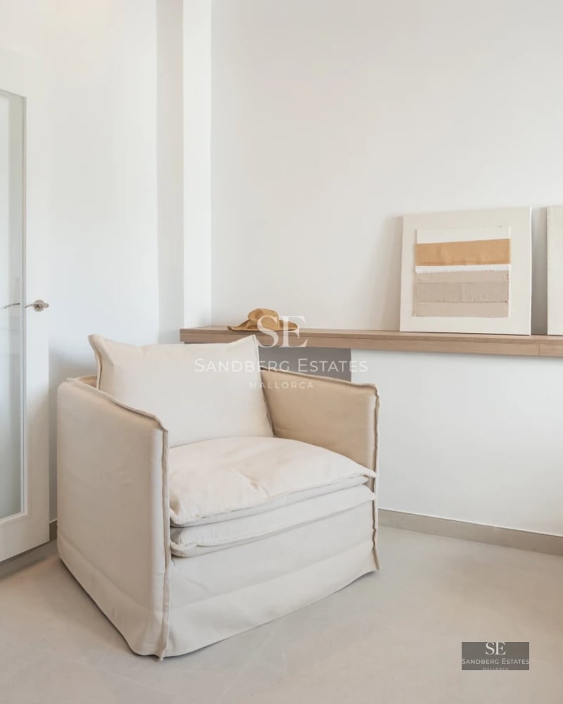 View of an infinity pool with sun loungers, surrounded by lush greenery and panoramic sea views. Modern and elegant design.