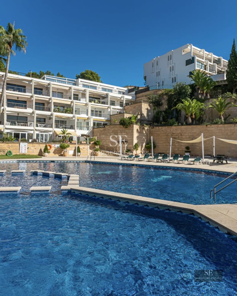 View of modern villa with infinity pool and lush garden. Sleek architectural design and manicured landscaping.