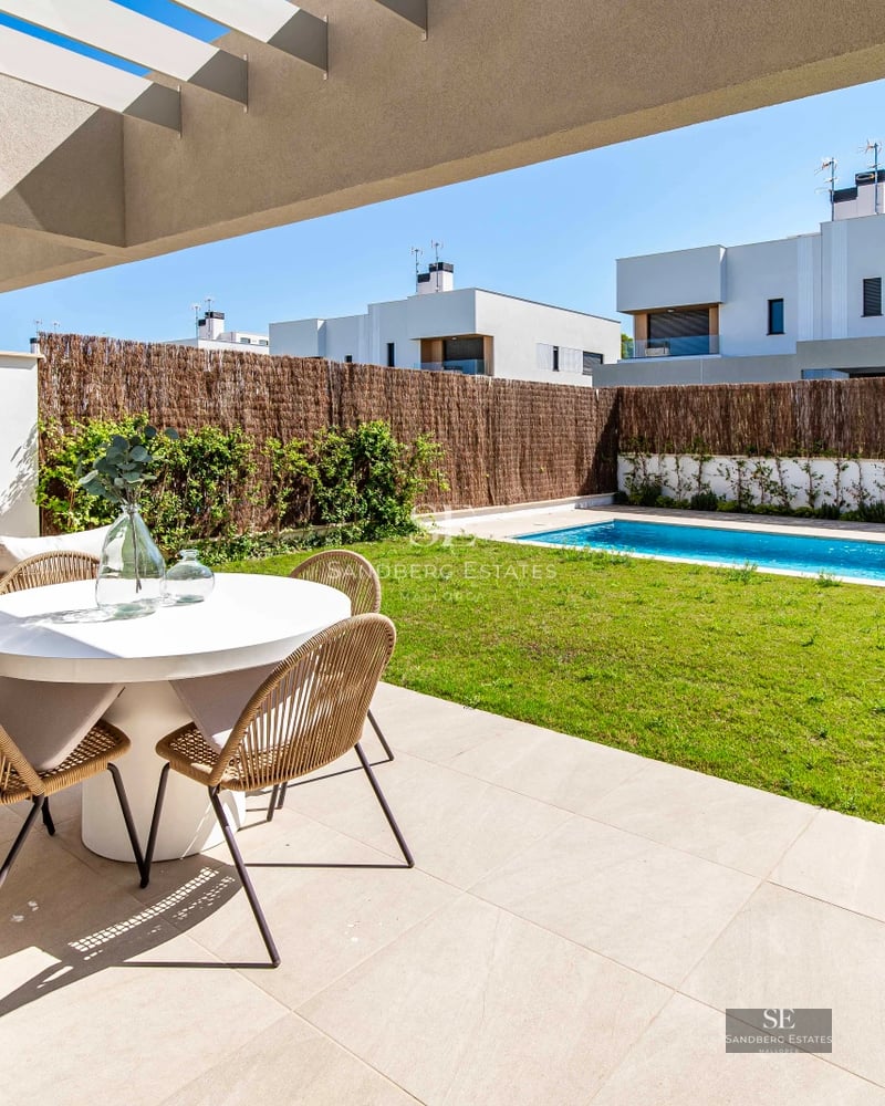 Exterior view of modern villa with pool, large windows, and lush garden. Contemporary architecture and landscape design.