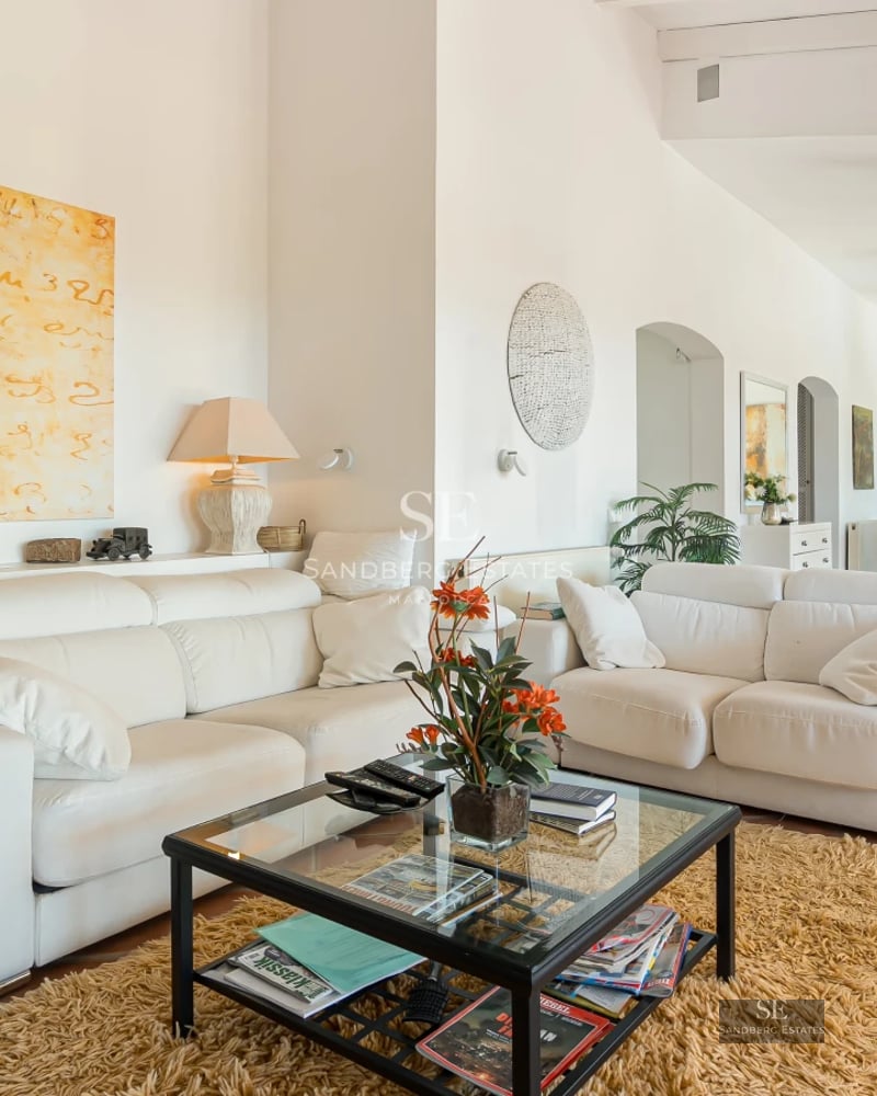 Exterior view of a modern villa featuring a pool, expansive terraces, lush gardens, and clean, minimalist architectural design.