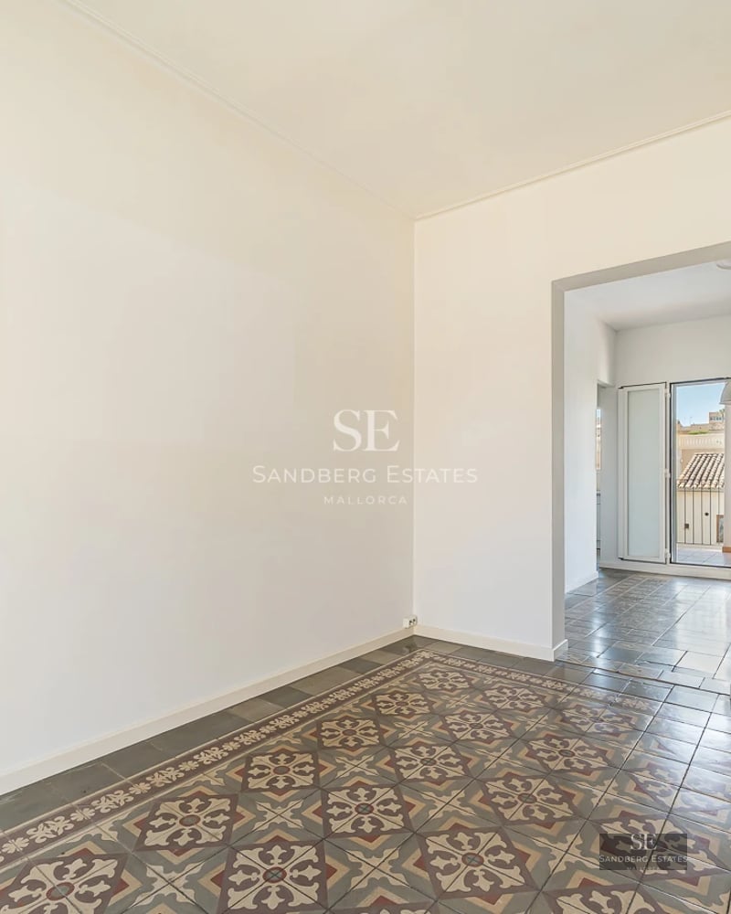 View of a private pool with sun loungers and umbrellas, surrounded by lush greenery and a modern house with large windows.