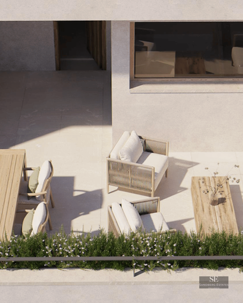 Bird's eye view of a sunlit modern terrace featuring a lounge area, dining table, and outdoor kitchen with a grill.
