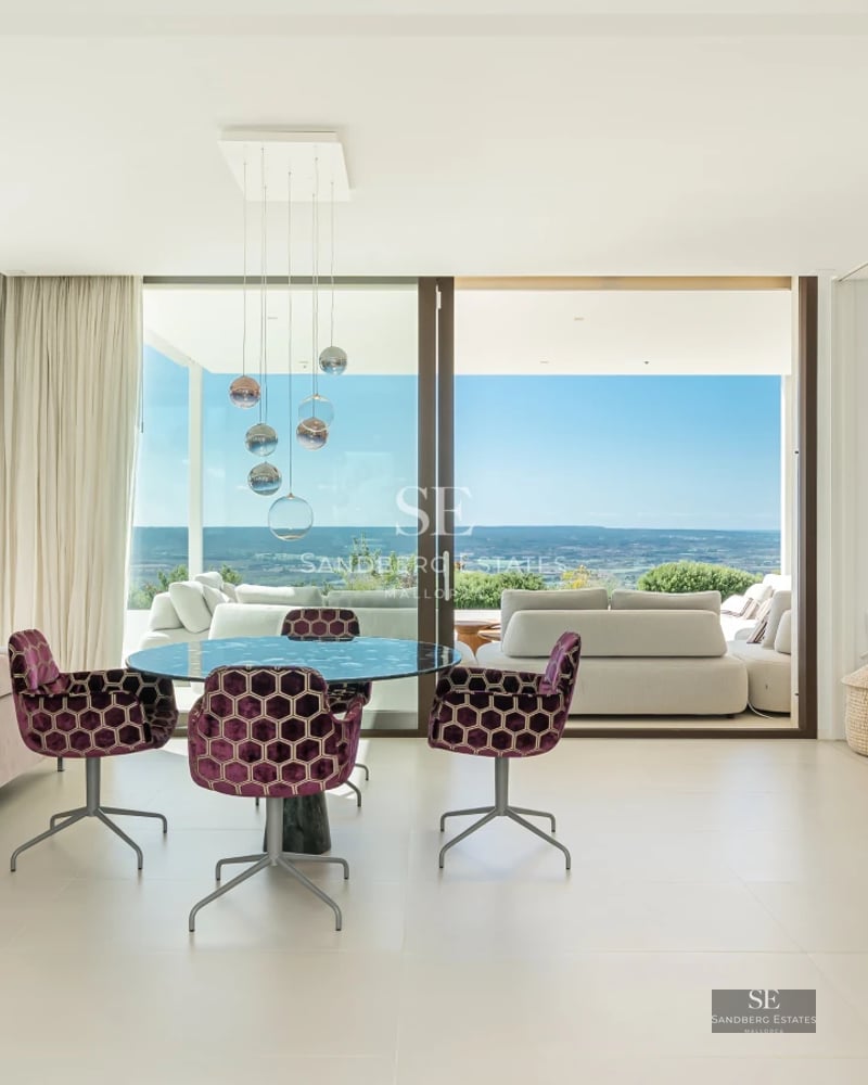 Exterior view of a modern villa featuring an infinity pool, sun loungers, and lush garden. Minimalist architecture with expansive windows.