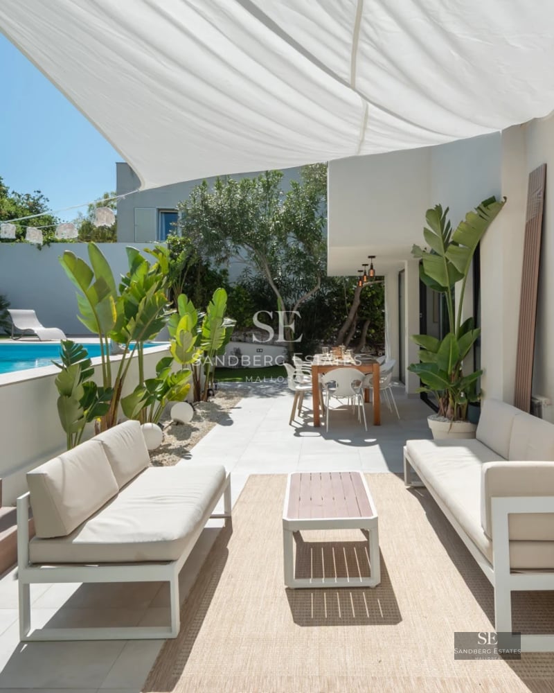 Panoramic view of a modern villa featuring an infinity pool, wooden deck, and lush garden. Elegant architecture and high-quality finishes.