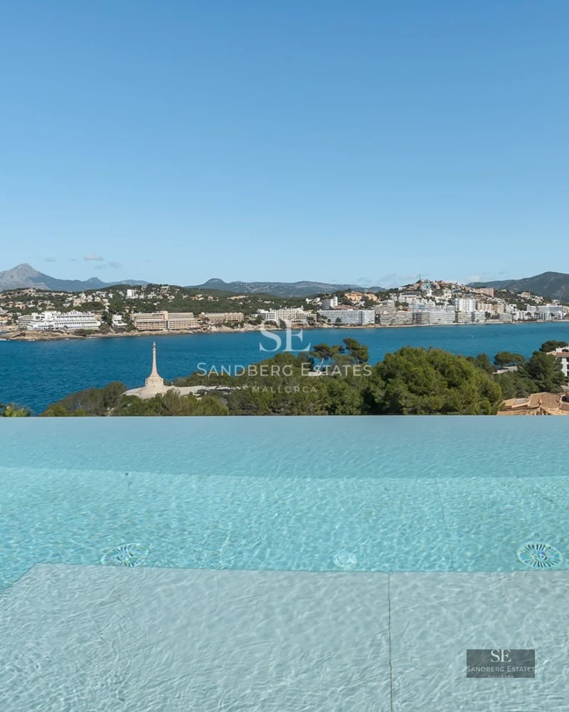 Spacious terrace with swimming pool, sun loungers, and seating area. Modern design with garden view. Ambient lighting.