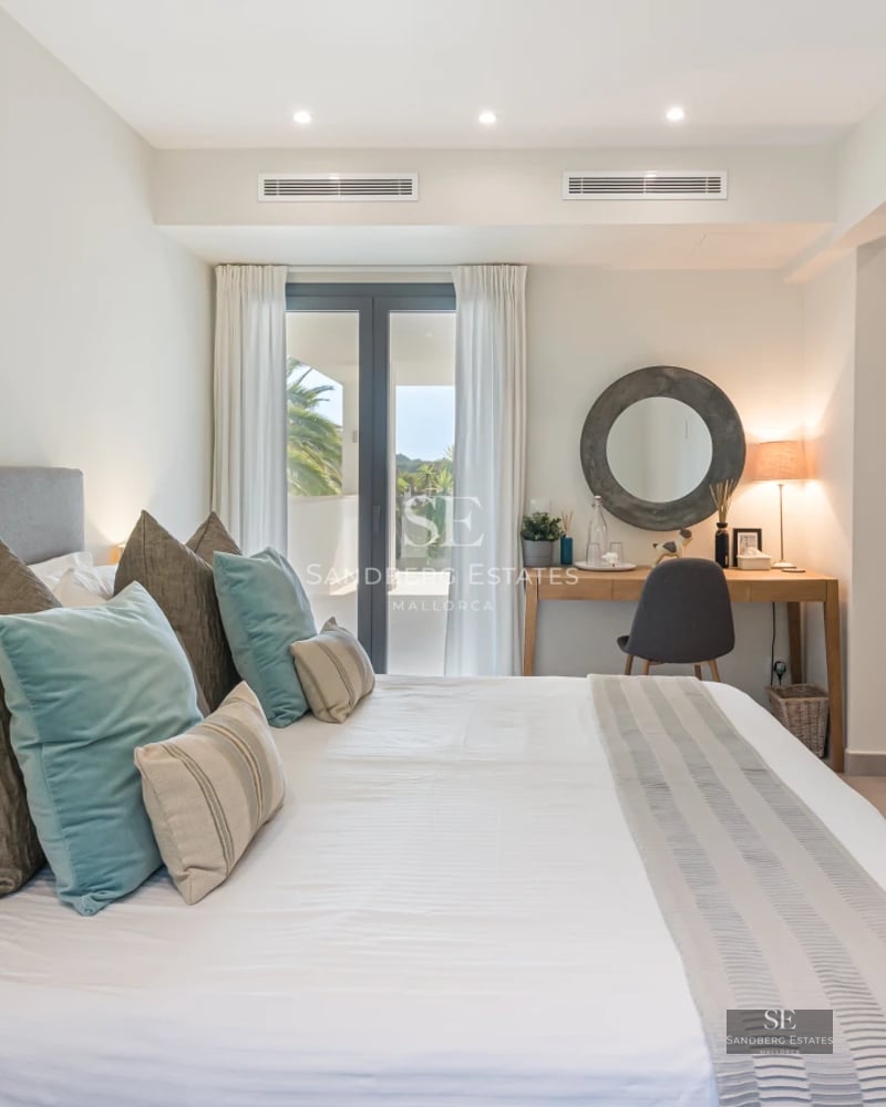 Spacious balcony with panoramic sea views. Modern furniture, light wood floors, and glass railings. Abundant natural lighting.