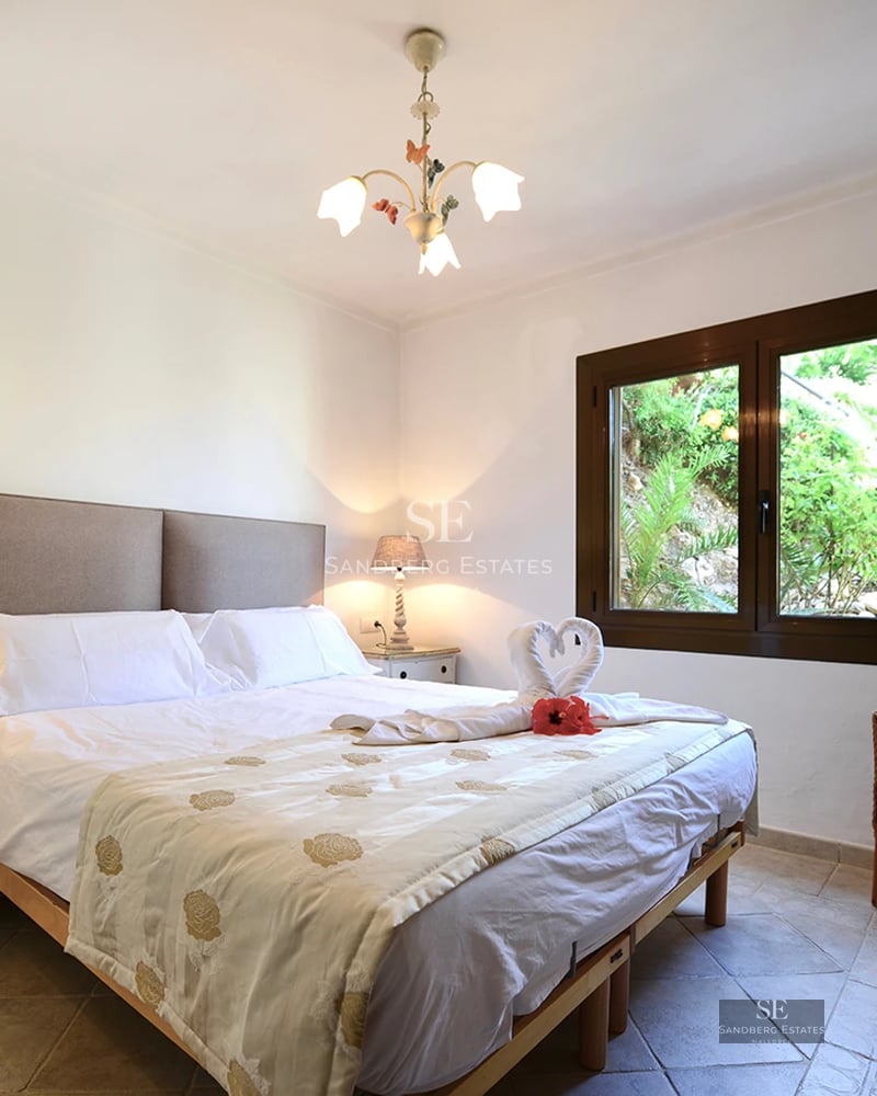 Exterior view of a modern villa with a pool, garden, and large windows. Minimalist architecture and high-quality finishes.