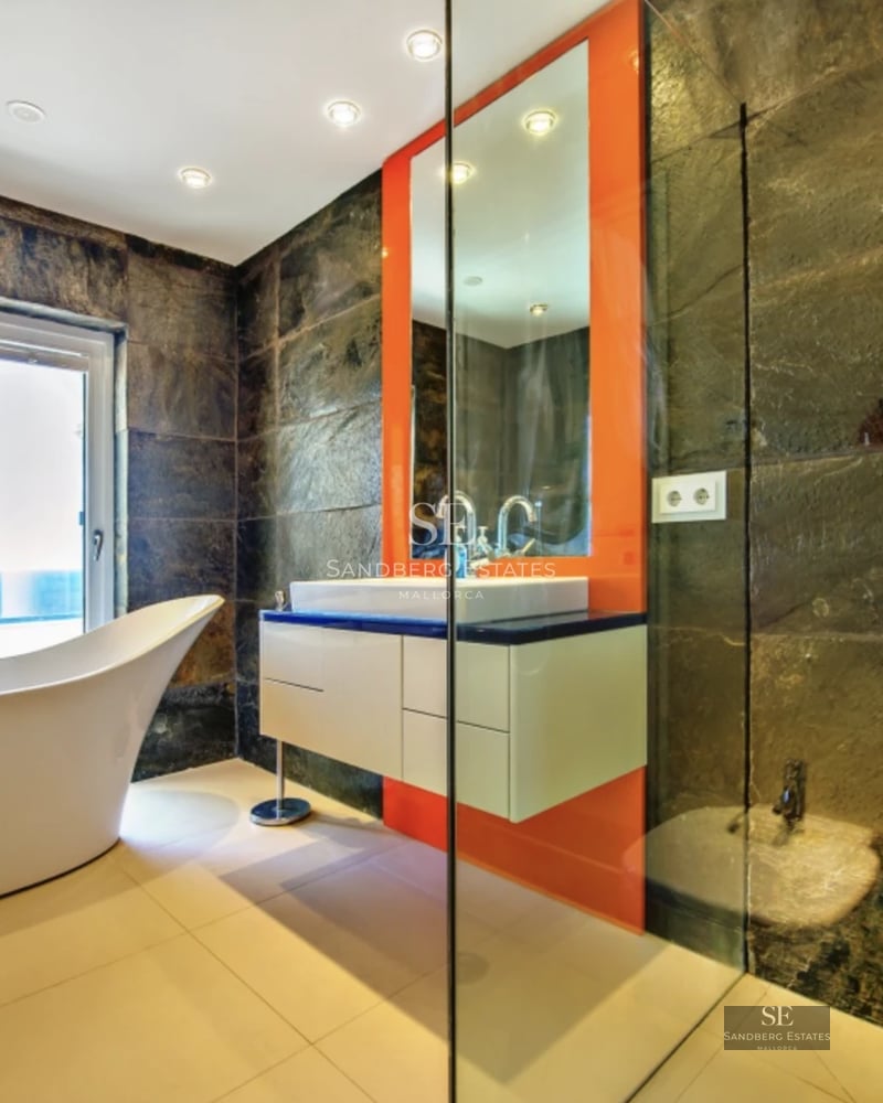 Spacious living room featuring large windows, panoramic sea views, light wood floors, and modern minimalist furniture.