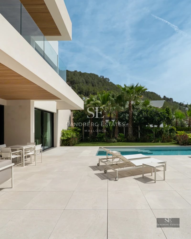 Spacious and bright living room featuring a fireplace, panoramic windows, and modern designer furniture. Breathtaking views.