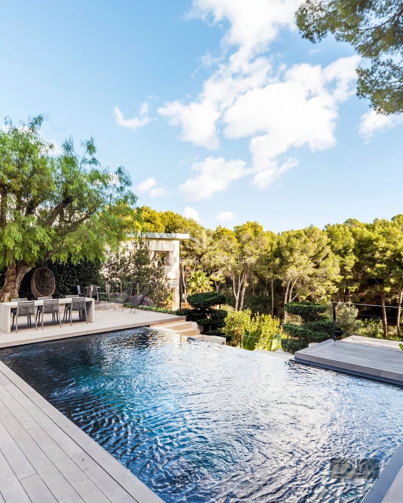 Spacious pool surrounded by lush garden and modern architecture. Panoramic views and exclusive design details.