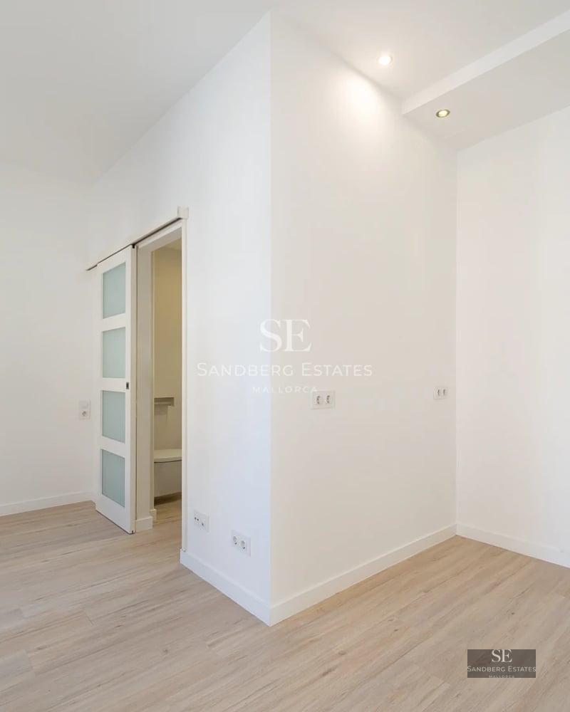 Spacious terrace featuring an infinity pool with ocean views. Modern furniture, glass railings, and lush vegetation.