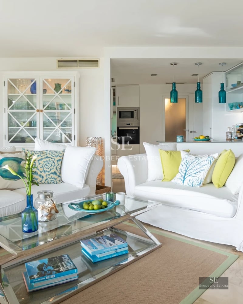 Spacious living room with panoramic windows, sea view, modern furniture, neutral color palette, and abundant natural light.