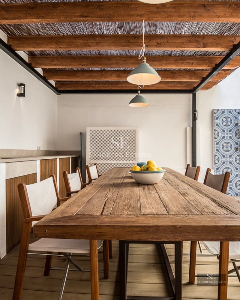 View of a luxury infinity pool with sun loungers. Modern architecture with large windows and lush gardens.