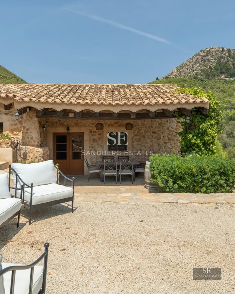 Spacious terrace with pool and views of greenery. Modern design with wood and natural stone. High-end outdoor furniture.