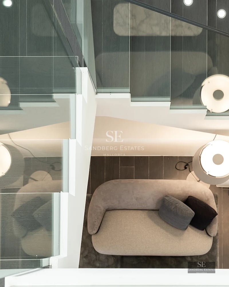 A top-down architectural view of a modern staircase with dark treads, glass railings, and integrated LED lighting.