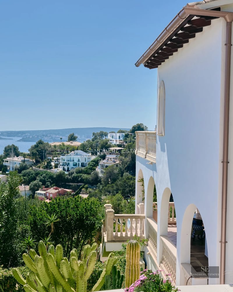 Garden view featuring a pool, modern furniture, and lush landscaping. Architectural details highlight the property's elegance.