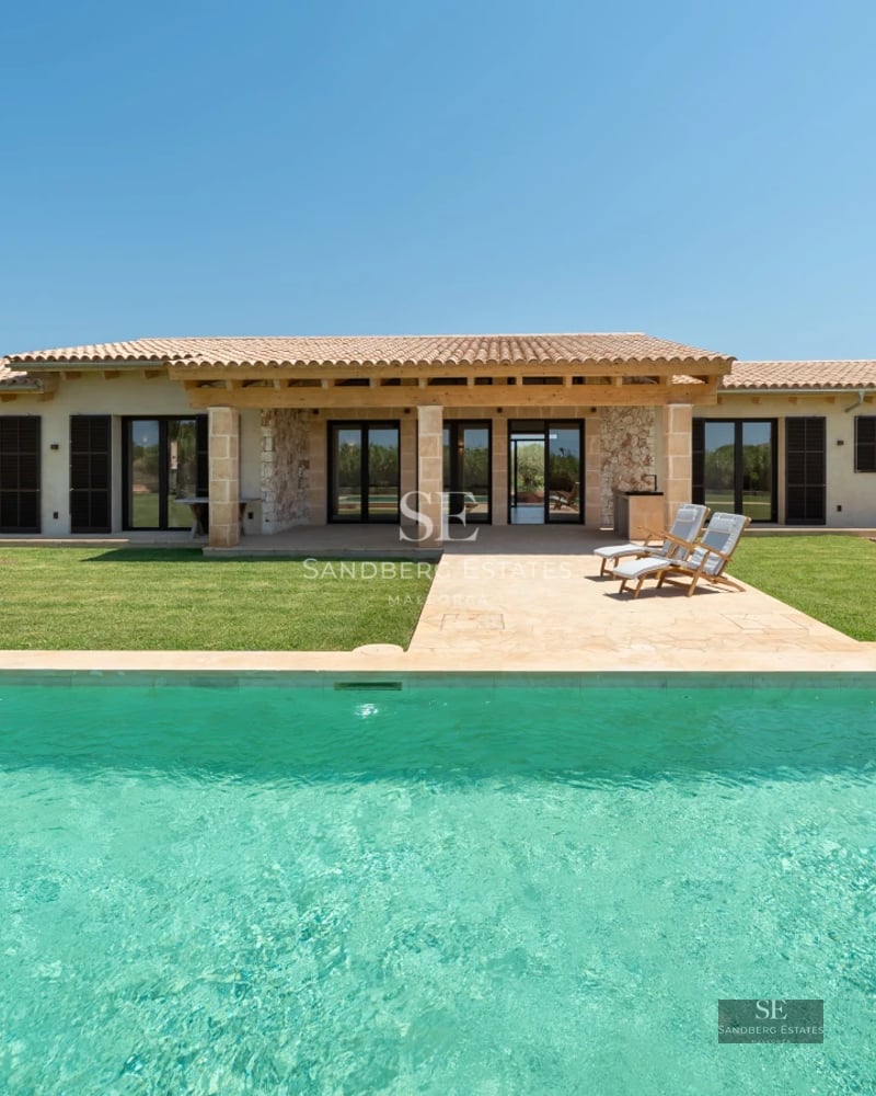 Bright living room with direct access to pool. Large windows, light wood floors and minimalist modern design. Elegant interior.