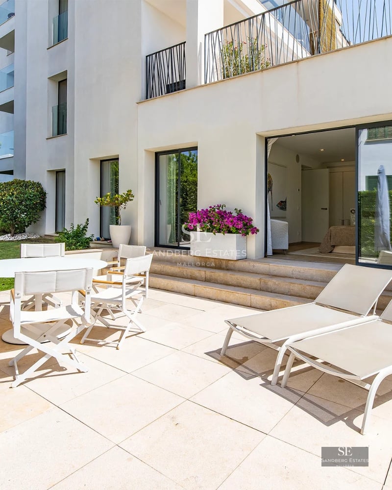 Exterior view of a modern villa featuring an infinity pool and lush garden. Minimalist architecture, large windows, and landscaped grounds.