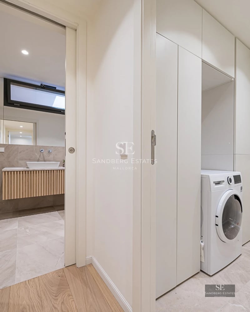 Spacious living room with panoramic windows, modern fireplace, light wood floors and designer furniture. Breathtaking views of the surroundings.