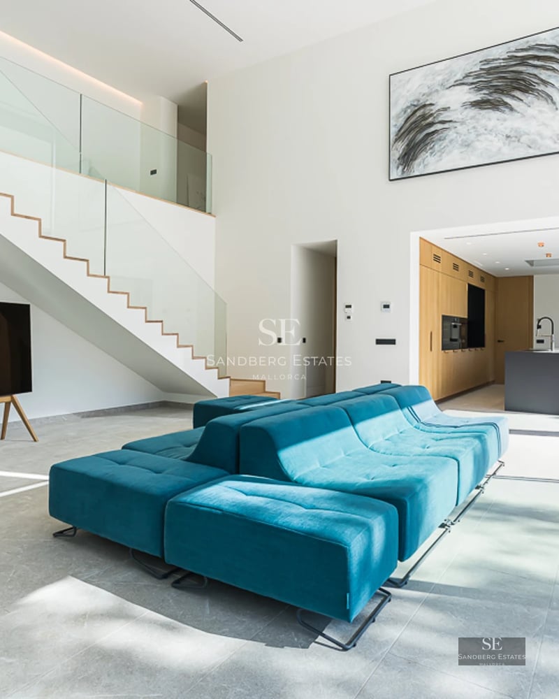 Vue piscine à débordement avec transats, parasols et jardins luxuriants. Design moderne avec éclairage d'ambiance.