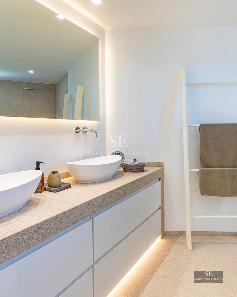 Exterior view of modern villa featuring an infinity pool, lounge chairs, and lush greenery. Minimalist and elegant architectural design.