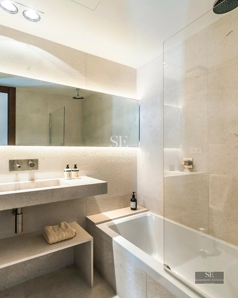 Exterior view of a modern villa featuring an infinity pool, spacious terrace, and lush vegetation. Minimalist architecture and high-end finishes.