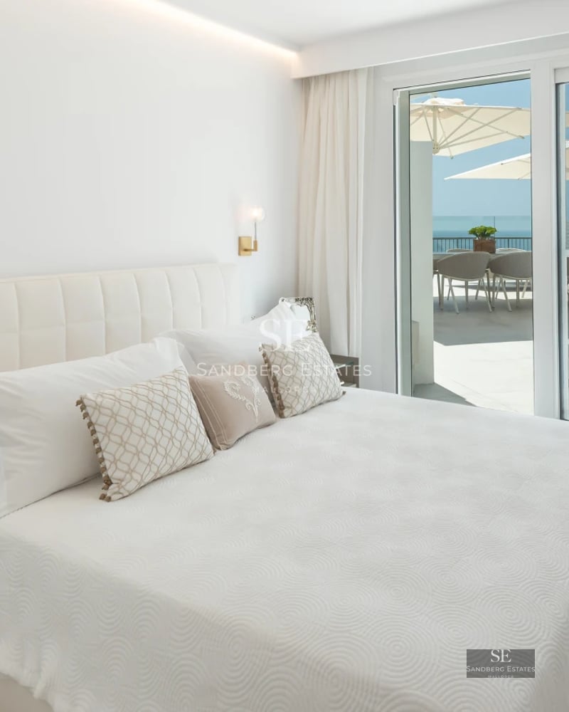 Bright interior with balcony and sea view. Modern design, wood flooring, and abundant natural light.