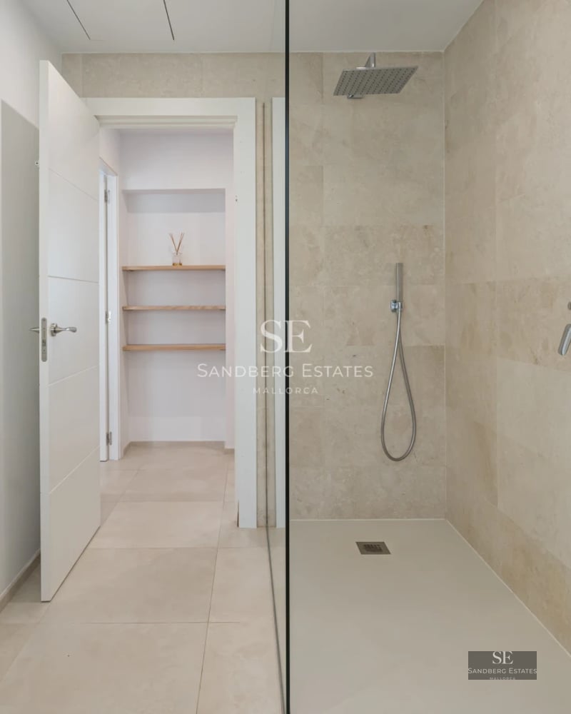 Spacious balcony with panoramic sea views. Modern outdoor furniture. Glass railing. Decorative plants. Wooden floors.