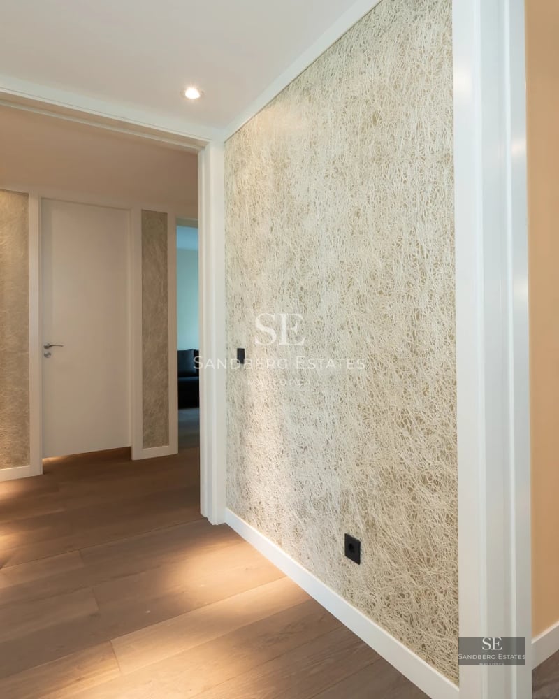 Spacious terrace with pool and panoramic views. Modern design, glass railing, wooden floors, and stylish sun loungers.