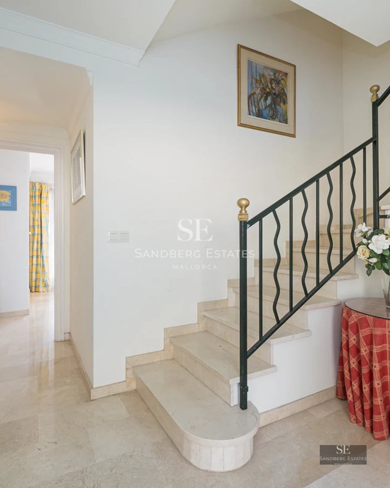 Minimalist balcony with glass railing, panoramic sea view, modern furniture and sleek design. Natural light.