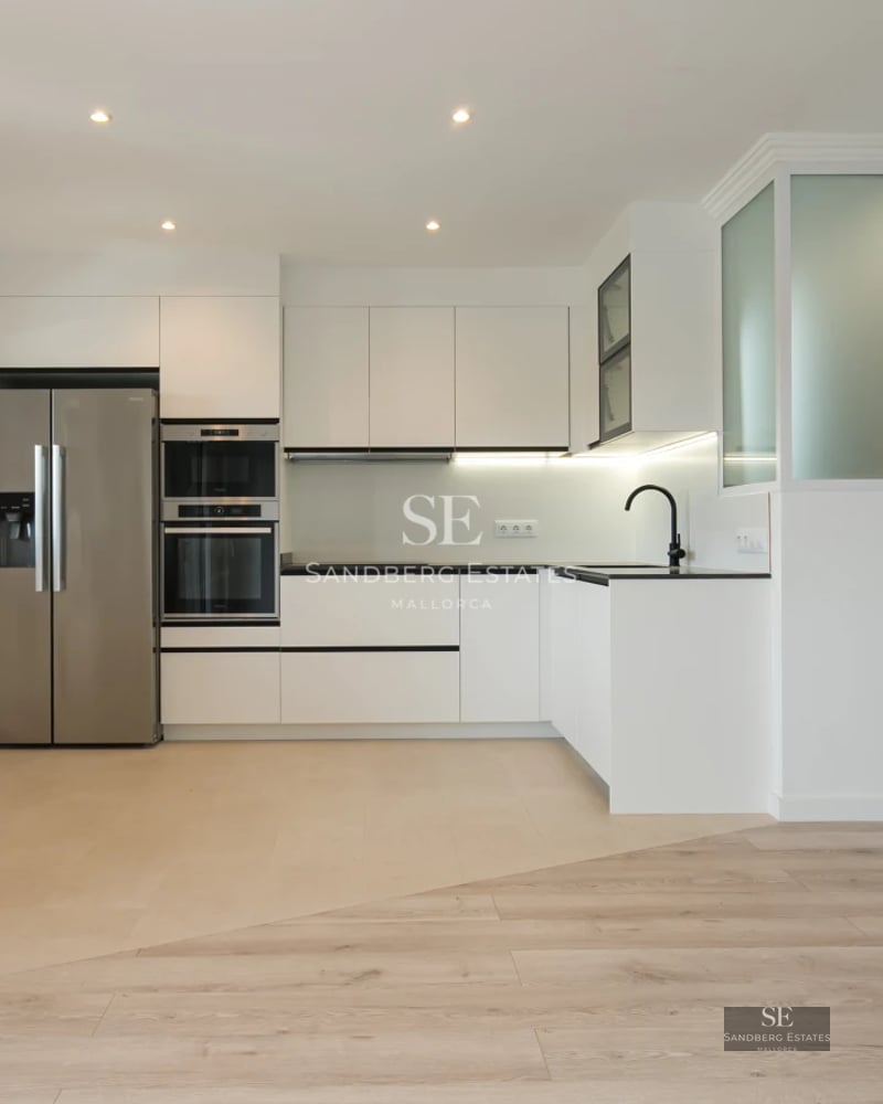 Spacious terrace with glass railing and panoramic sea views. Modern furniture, wooden floor. Ambient lighting.