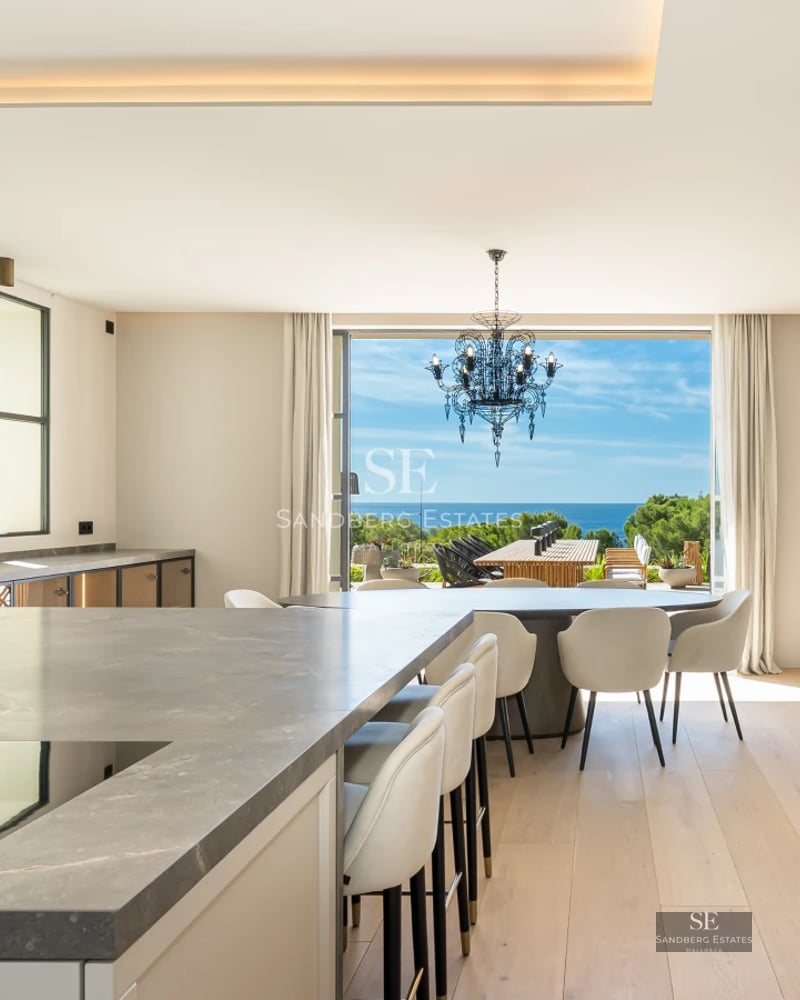 Exterior view of a luxury villa featuring a pool, large garden, and modern architecture. Warm lighting and high-quality finishes.