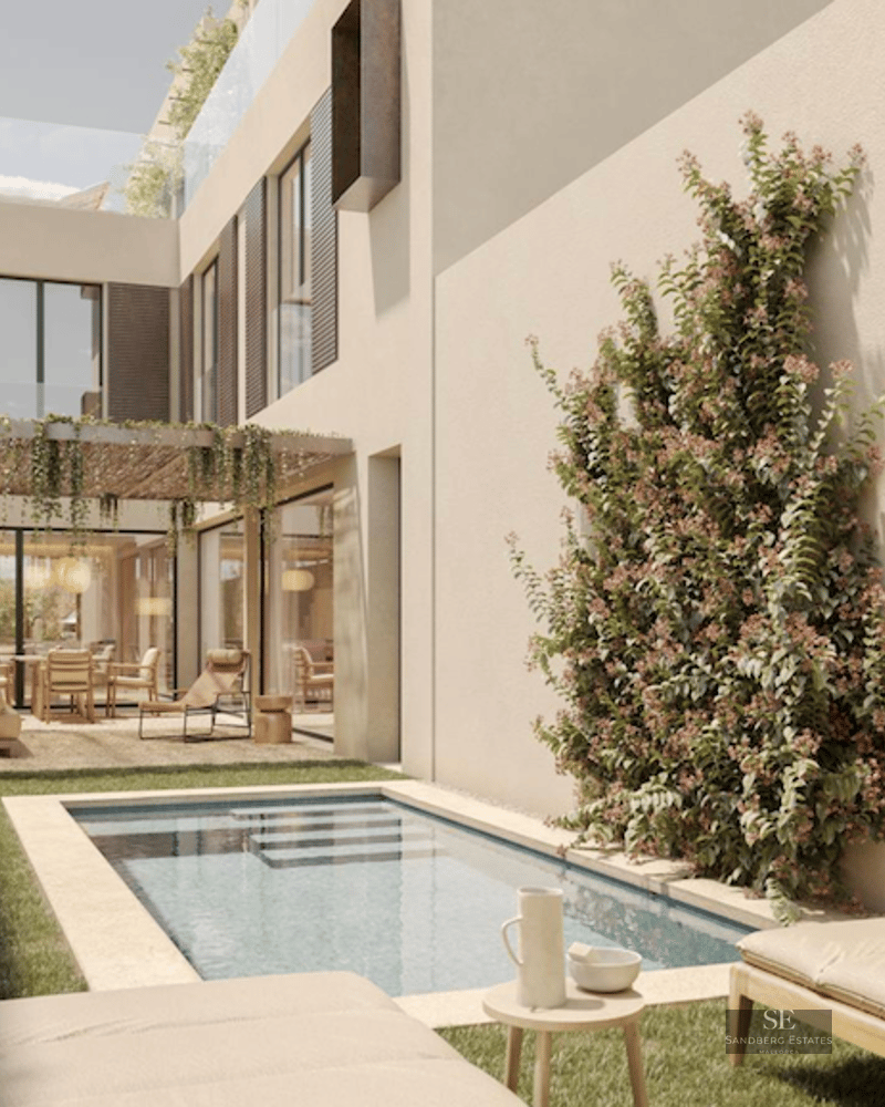 A sleek plunge pool in a Mediterranean-style garden with sun loungers, climbing flowers, and a shaded patio.