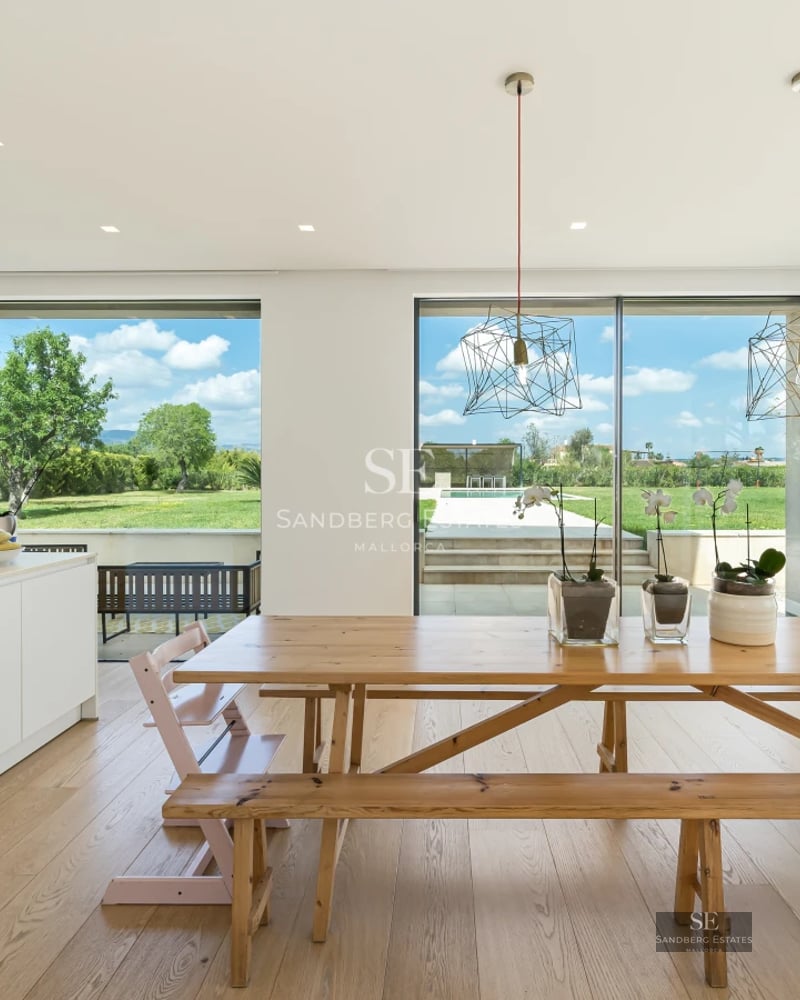 Spacious, bright living room featuring modern sofas, elegant fireplace, and large windows overlooking the outdoors. Minimalist and cozy interior.