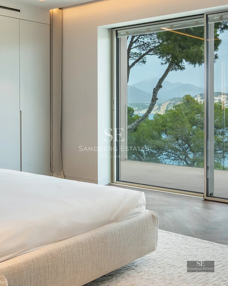 Expansive pool surrounded by lush greenery. Modern architecture with large windows and a sunny terrace. Luxurious ambiance.