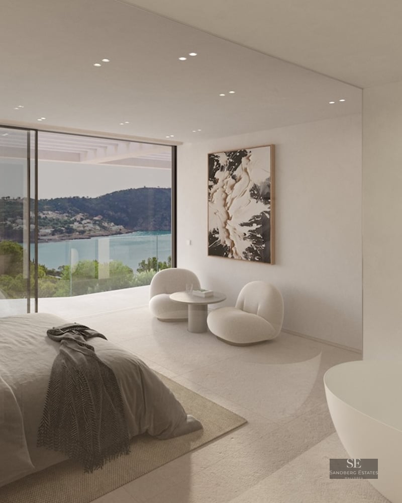 Modern bedroom featuring floor-to-ceiling windows with bay views, an integrated bathtub, and designer furniture in neutral tones.