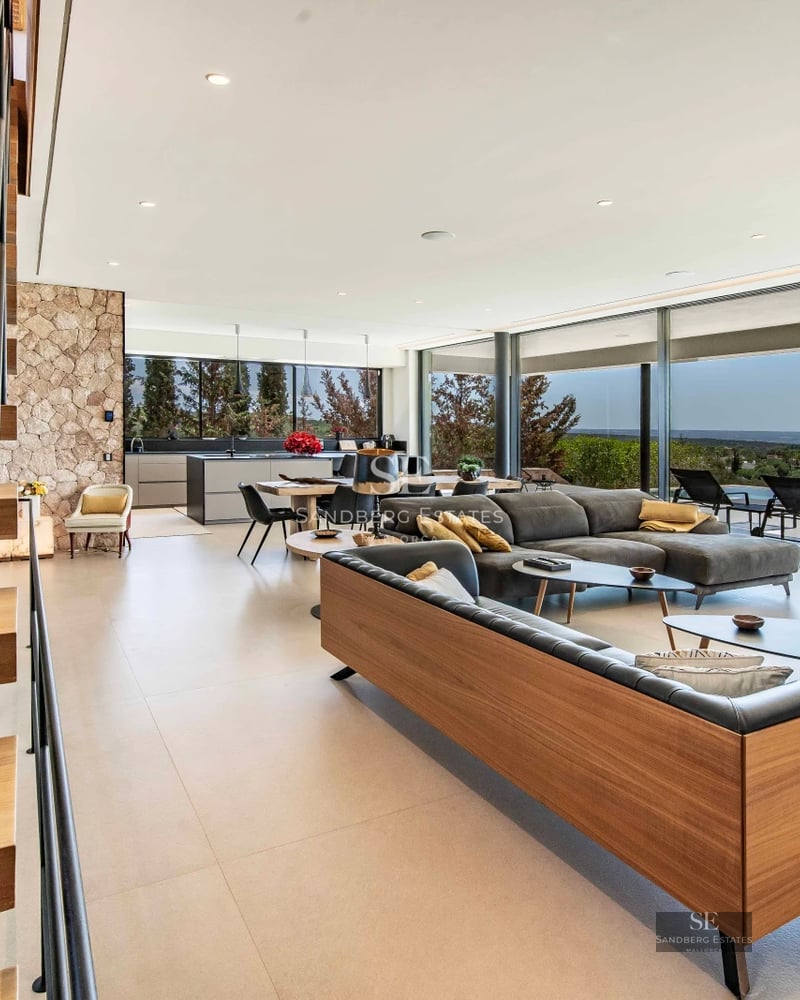 Spacious balcony with ocean view. Glass railing, wood flooring, and modern furniture. Elegant and bright design.