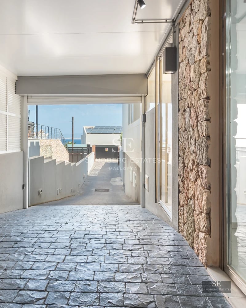 View of infinity pool surrounded by greenery. Modern outdoor furniture and elegant architectural design.