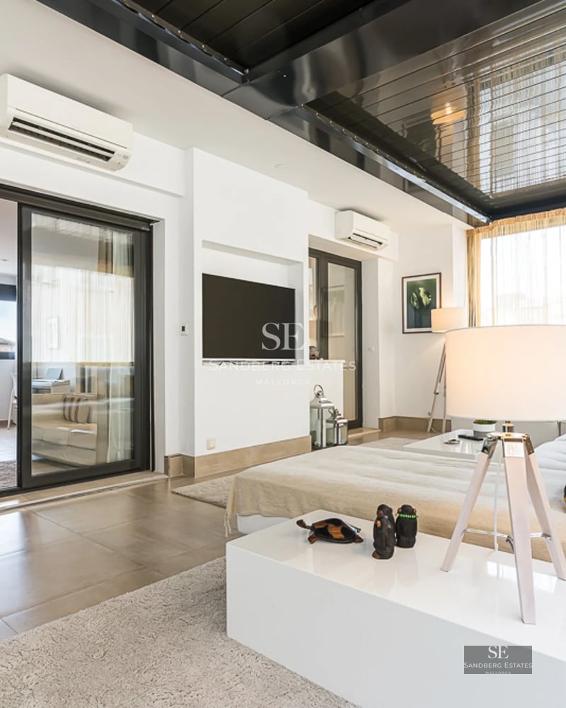 Spacious living room with fireplace, large windows and access to a terrace with views. Modern decoration in neutral tones.