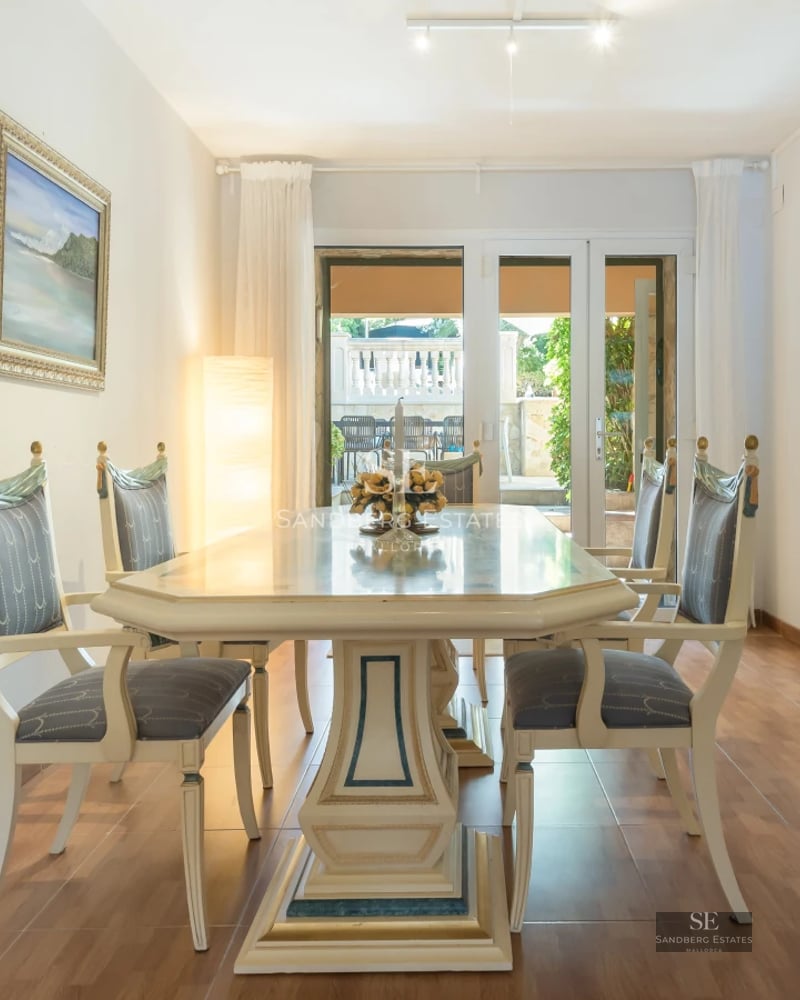 Spacious living room with infinity pool visible through large windows. Modern design, natural light, and hardwood floors.