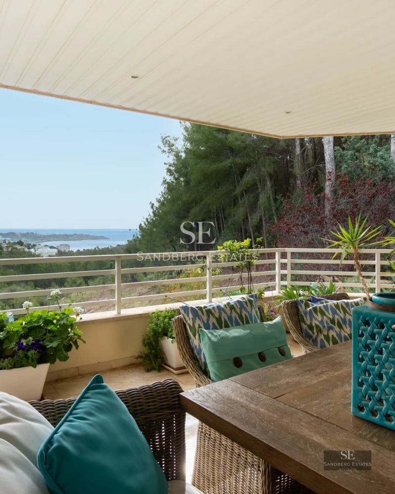 Exterior view of a modern villa featuring an infinity pool, large windows, and lush garden. Minimalist architecture and high-end finishes.
