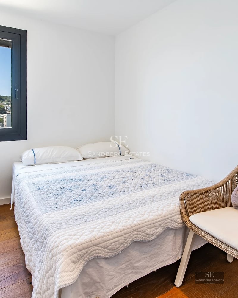 View of a modern infinity pool with panoramic views. Sleek design with sun loungers and lush vegetation.