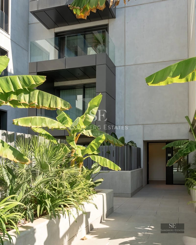 View of a modern villa featuring an infinity pool, lush gardens, and panoramic sea views. Minimalist and elegant architectural design.