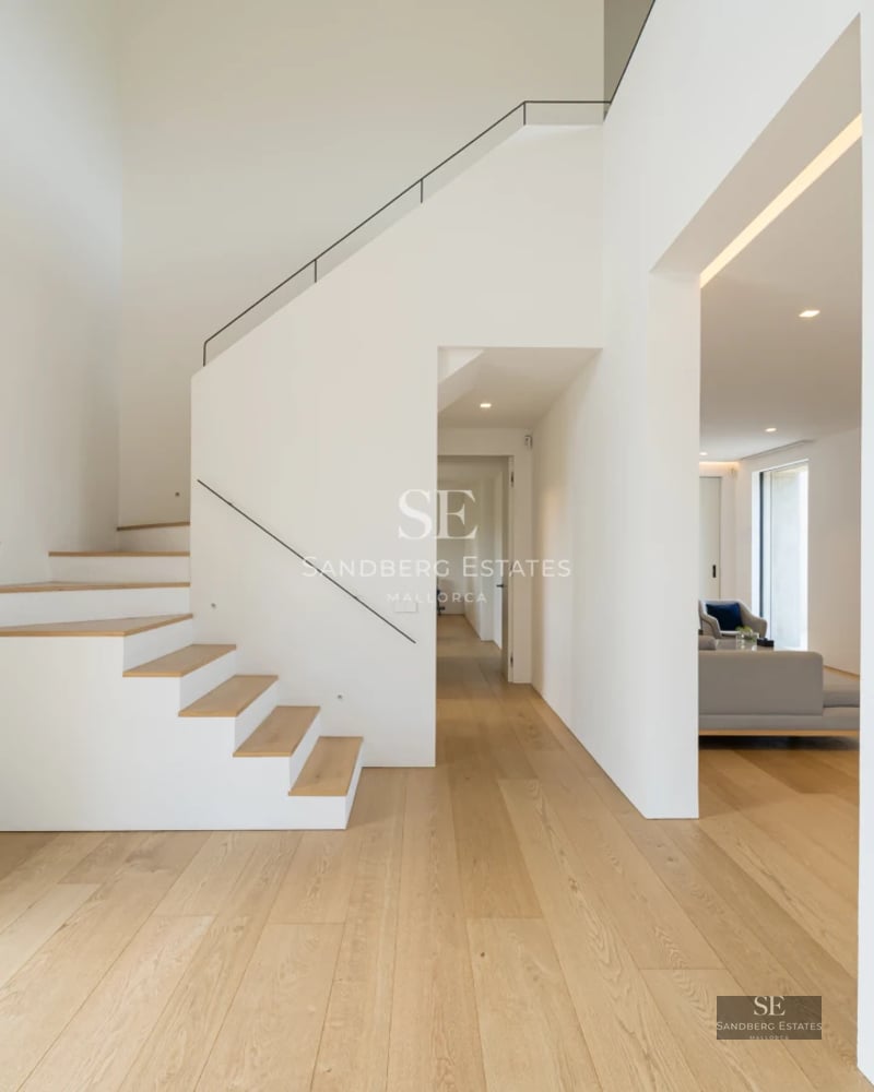 Spacious living room with balcony and panoramic sea views. Large windows, wooden floors, and modern design. Bright and elegant.