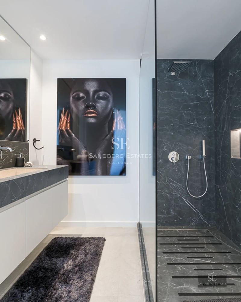 Spacious living room with fireplace, beige sofas, large windows overlooking the garden and abundant natural light. Modern and elegant design.